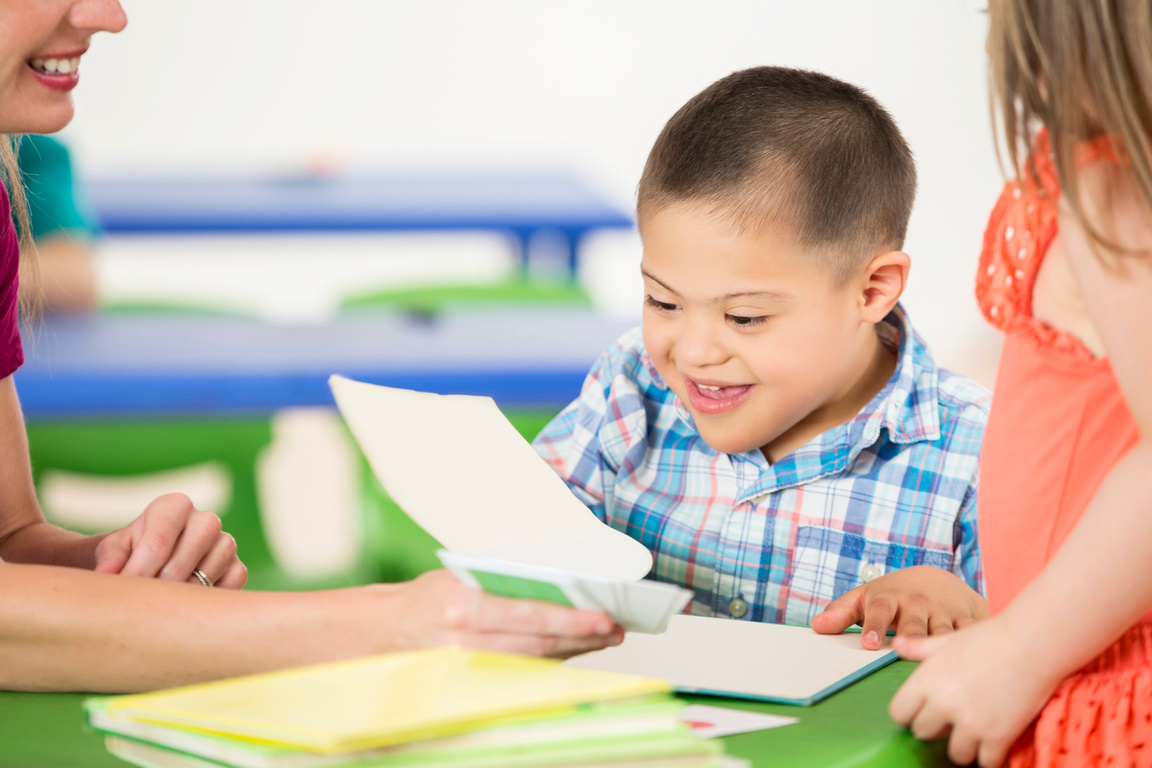 Preschool age child with Down Syndrome learning in classroom
